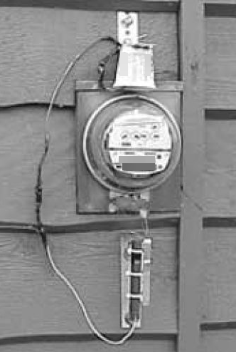 Photo of an electric meter showing jumpers bypassing the meter.